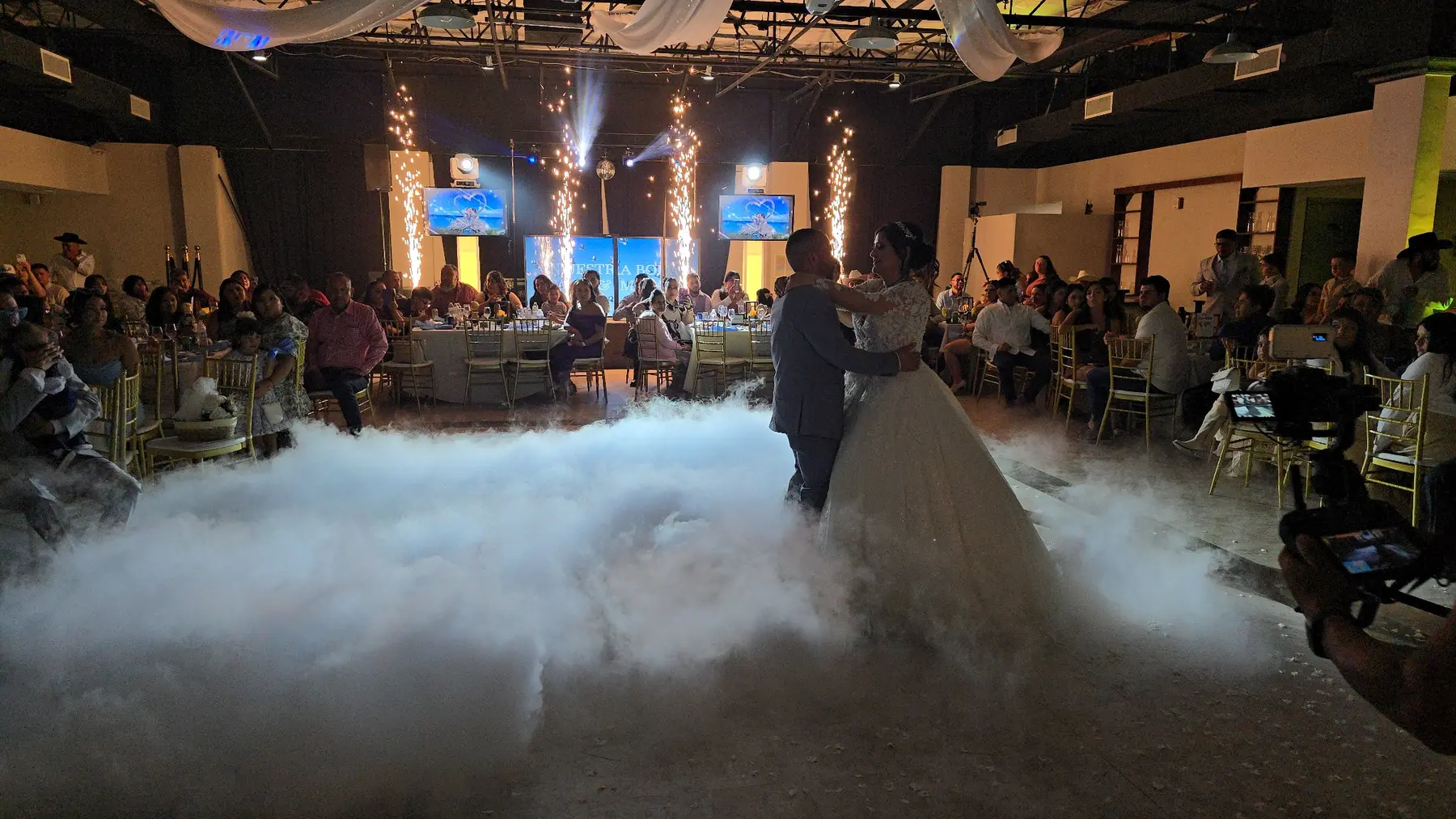 Primer baile de boda rodeado por nubes y pirotecnia fría