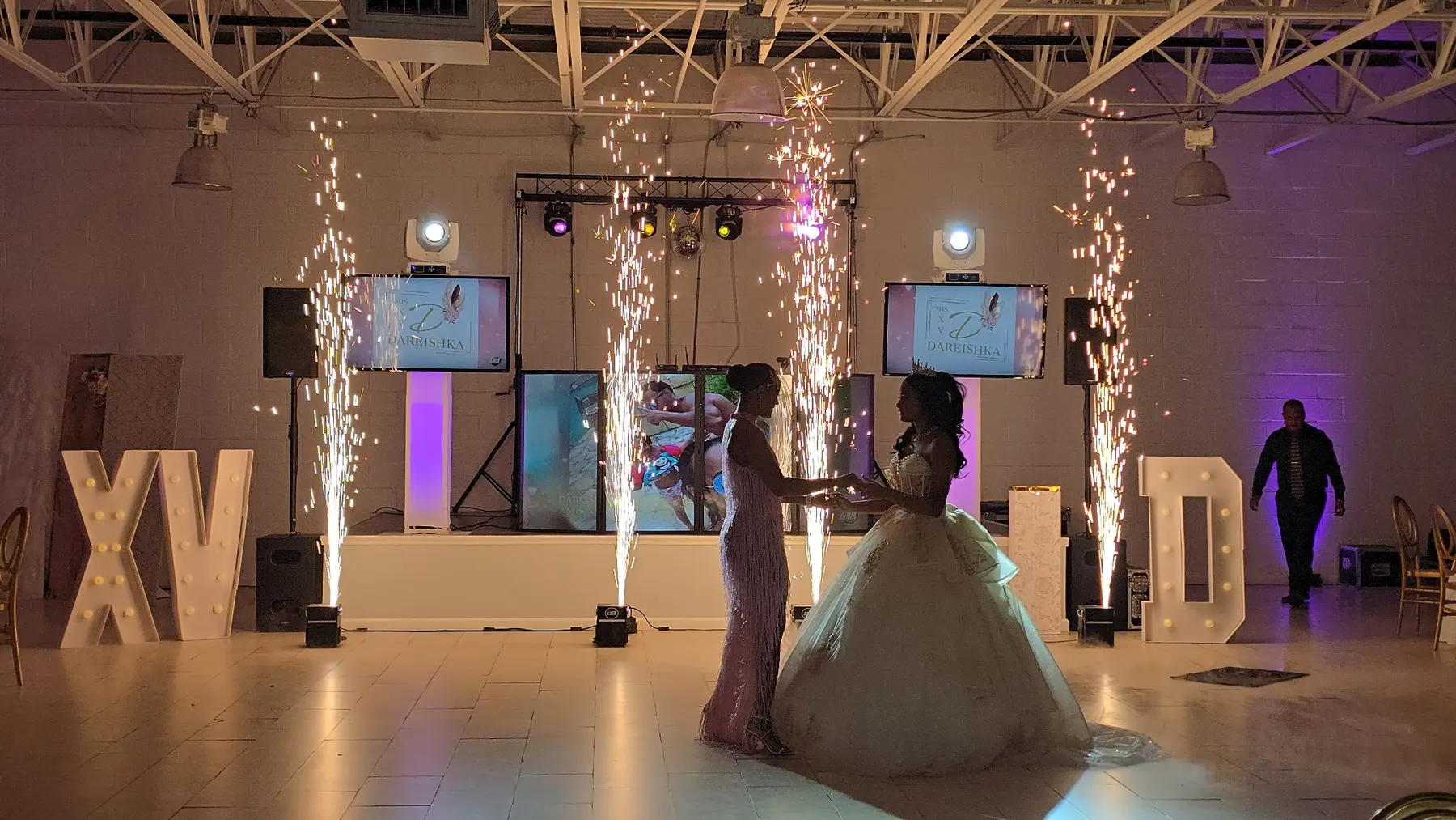 Quinceañera y acompañante rodeadas por fuentes de pirotecnia fría