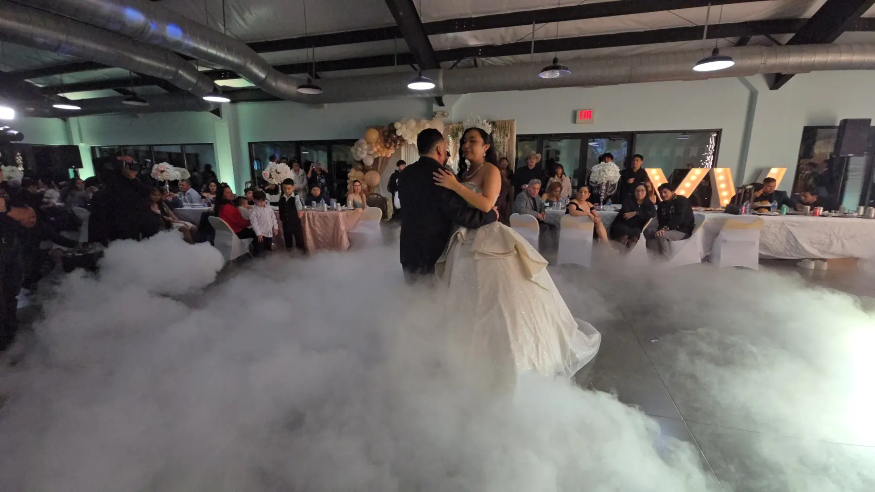 Quinceañera bailando sobre una pista cubierta de nubes