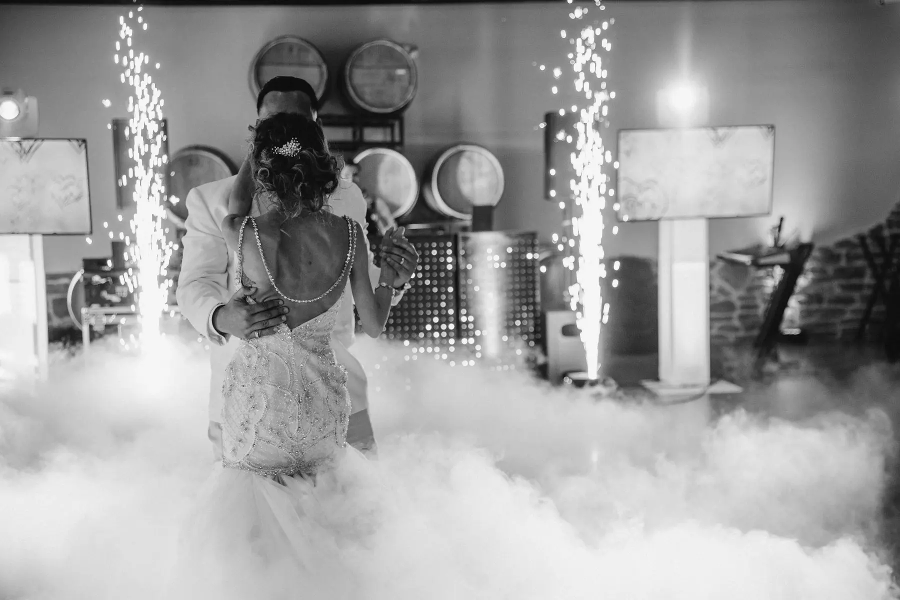 Novios bailando entre pirotecnia fría en fotografía blanco y negro