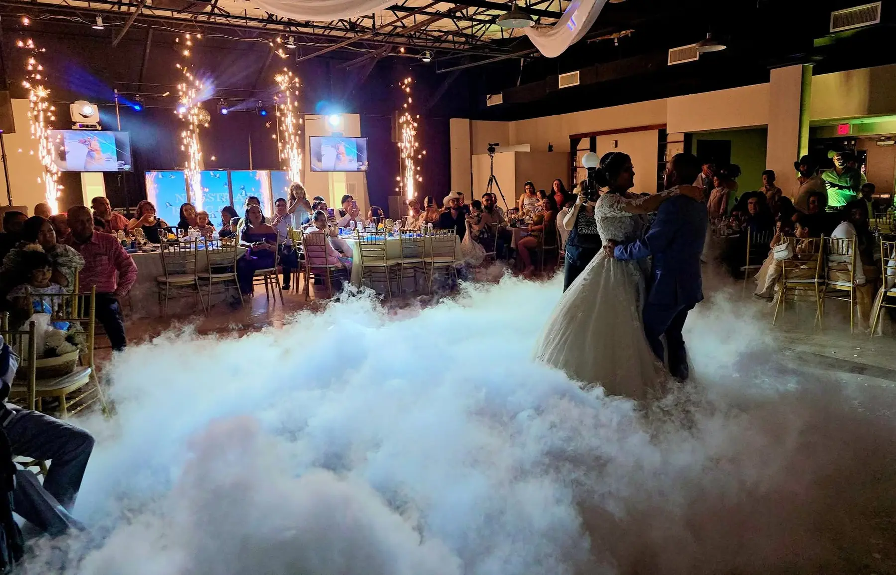 Pareja bailando con una producción completa de nubes y pirotecnia fría